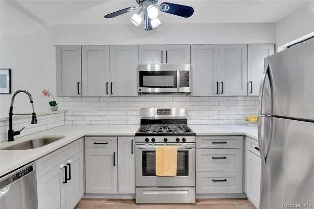 a kitchen with cabinets stainless steel appliances and a sink