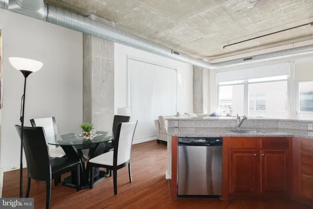 a kitchen with granite countertop a table chairs stove and wooden floor