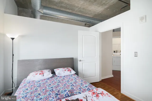 a bedroom with a bed and wooden floor