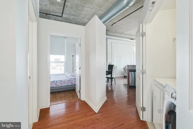 a view of a hallway with wooden floor a fireplace and a bathroom