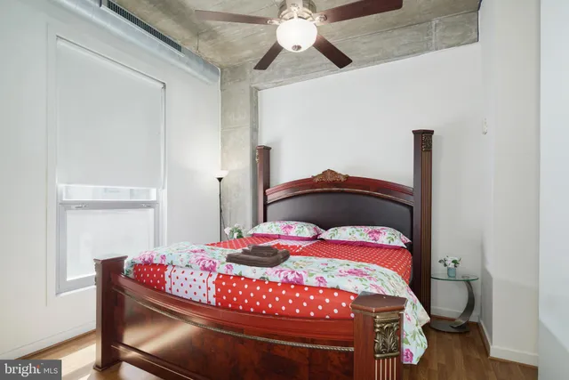 a bedroom with a bed and a chandelier fan