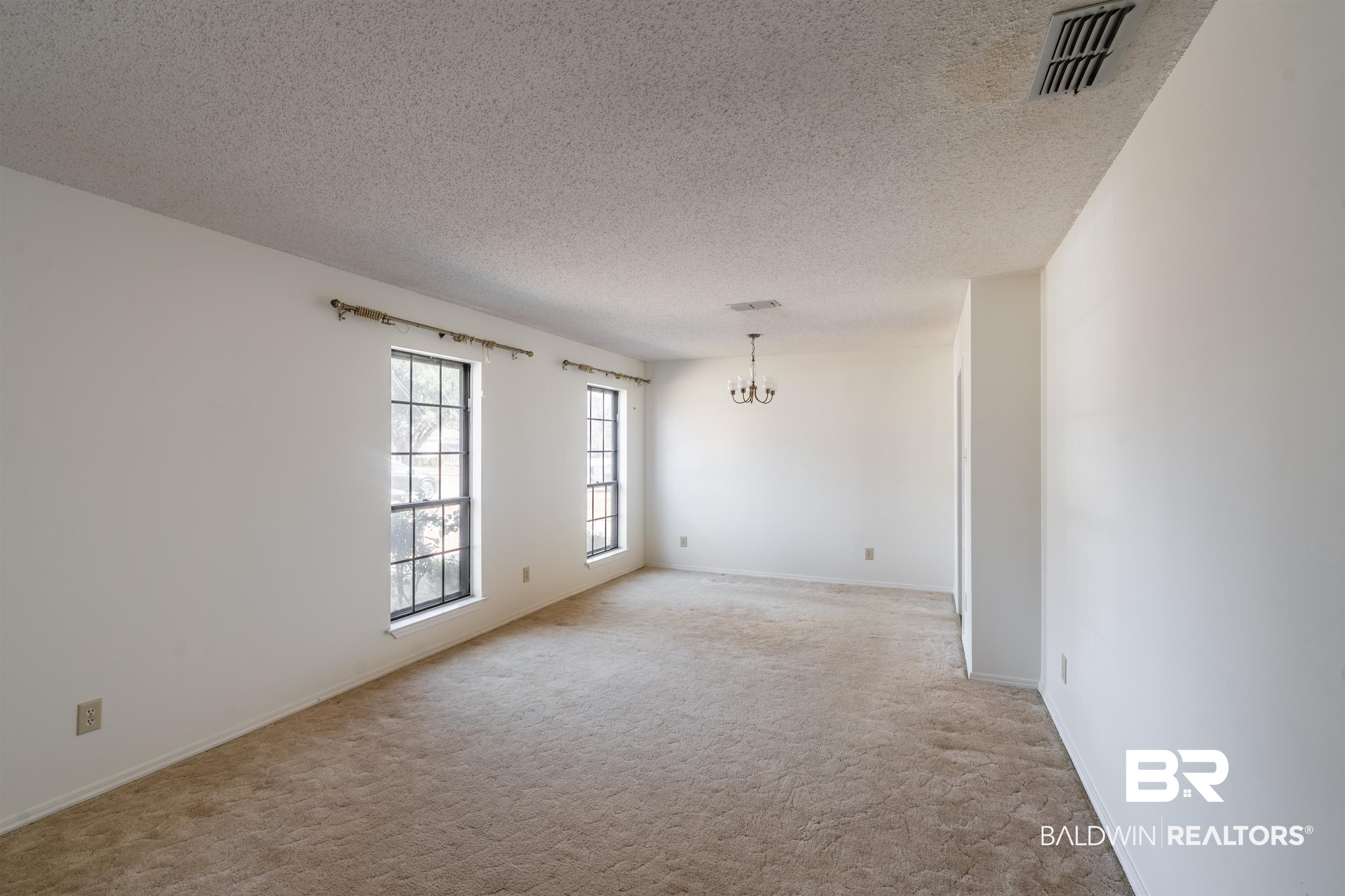 9751 Pine Knoll Road Mobile, AL 36608 - Photo 5 of 36 Unfurnished room featuring light carpet, suspended lighting, and a textured ceiling