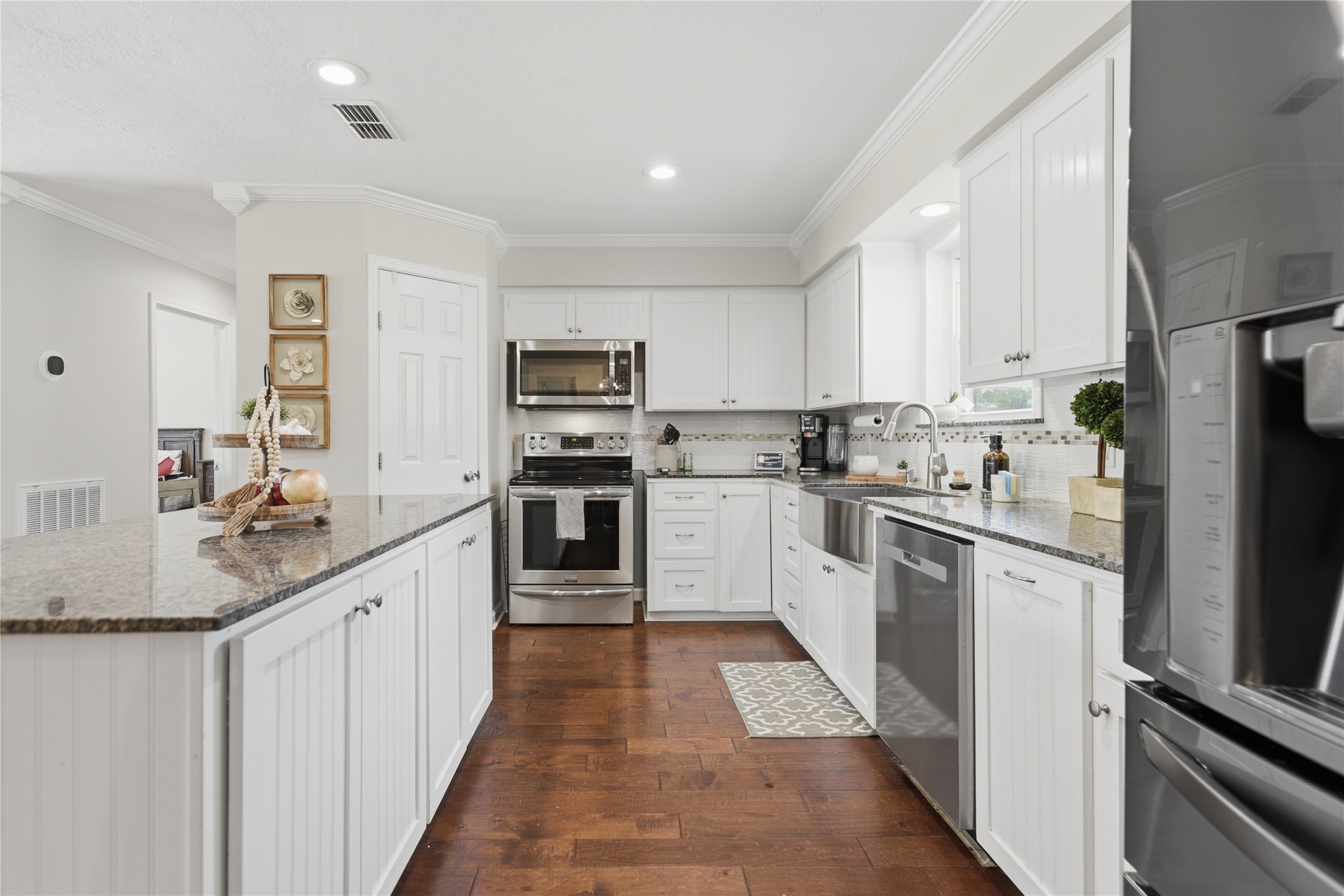 207 Briar Ridge Drive Bellville, TX 77418 - Photo 11 of 36 a kitchen with kitchen island granite countertop stainless steel appliances cabinets a sink and a counter top space