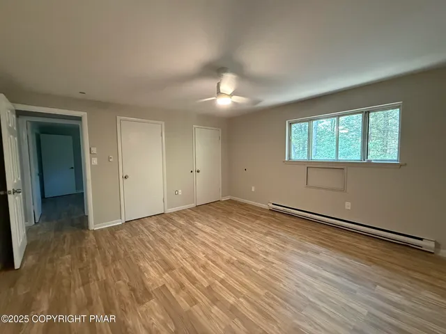 a view of a room with wooden floor and a window