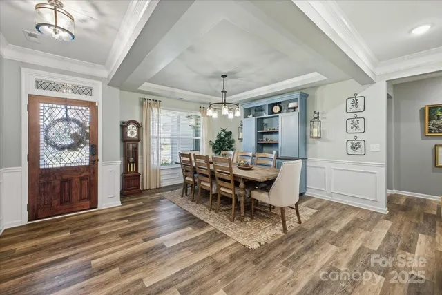 a dining room with furniture a chandelier and wooden floor