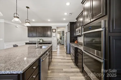 a kitchen with stainless steel appliances granite countertop a stove and a refrigerator