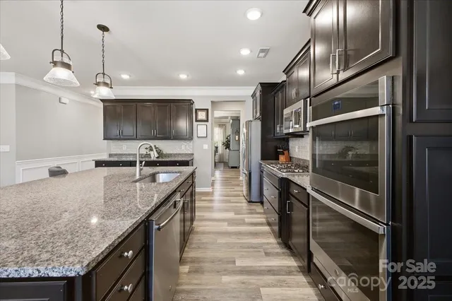 a kitchen with stainless steel appliances granite countertop a stove and a refrigerator