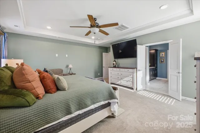 a bedroom with a bed and a view of living room