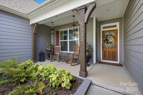 a front view of a house with chairs and table in patio