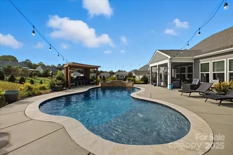 a view of a house with swimming pool and sitting area