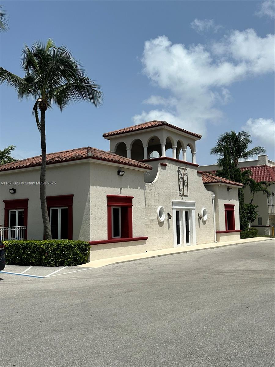 8600 Southwest 67th Avenue, Unit 908 Pinecrest, FL 33156 - Photo 2 of 25 a front view of a house with a garden