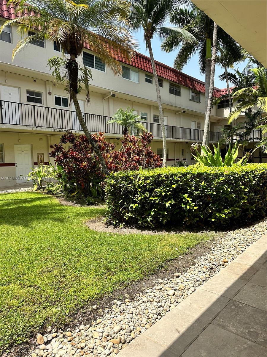 8600 Southwest 67th Avenue, Unit 908 Pinecrest, FL 33156 - Photo 7 of 25 a front view of a house with a yard and potted plants