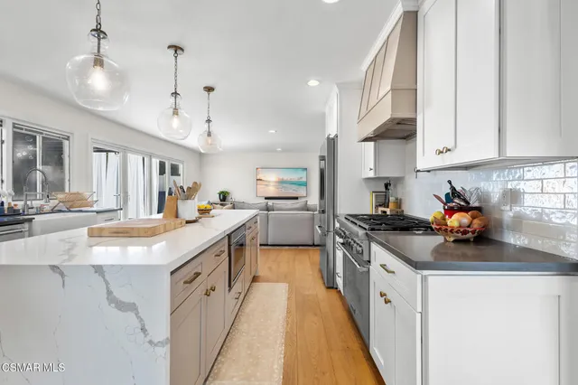 a kitchen with stainless steel appliances granite countertop a sink and cabinets