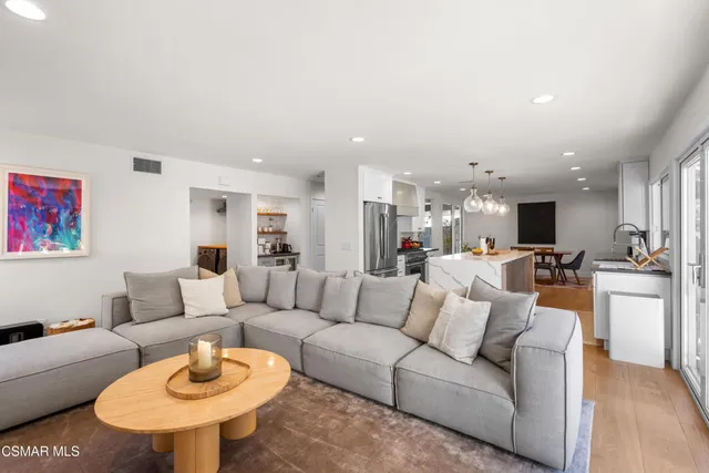 a living room with furniture kitchen and a table