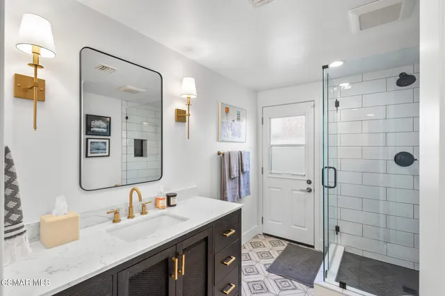 a bathroom with a double vanity sink mirror and shower