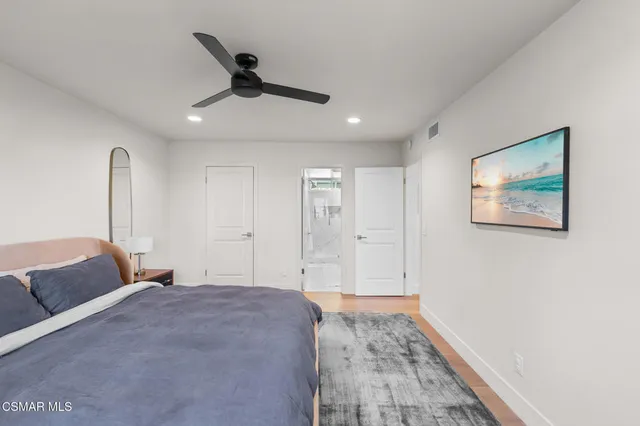 a bedroom with bed and ceiling fan