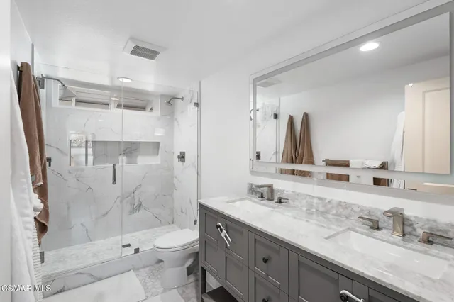 a bathroom with a granite countertop sink toilet and shower