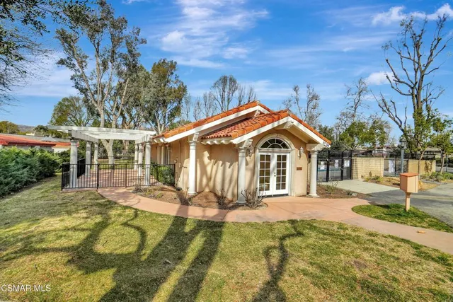 a front view of house with yard and trees around