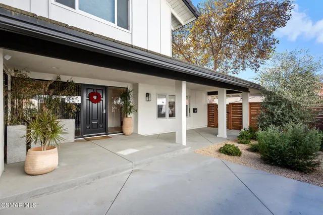a view of a house with chairs and potted plants