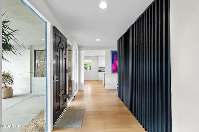 a view of a hallway with wooden floor and a potted plant