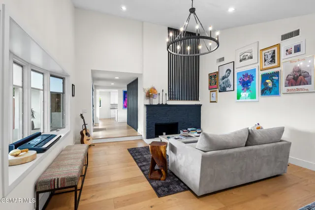 a living room with furniture a chandelier and a fireplace