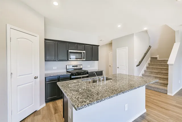 a kitchen with granite countertop a stove and a sink