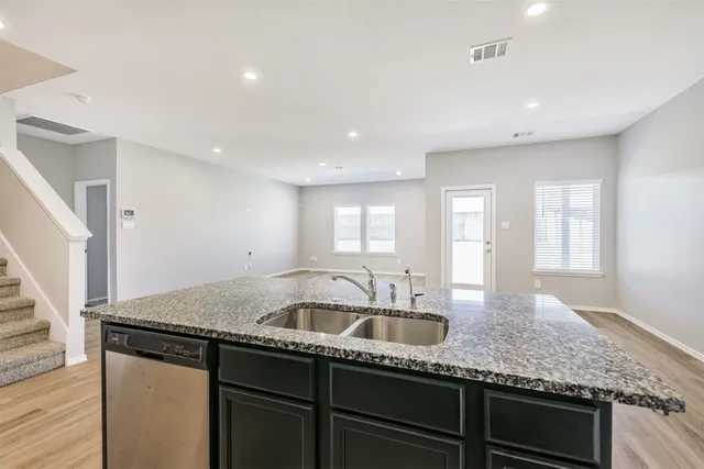 a kitchen with granite countertop kitchen island a sink appliances and cabinets