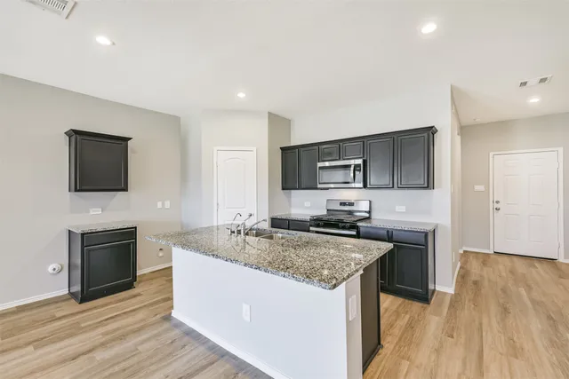 a kitchen with a sink stove and microwave