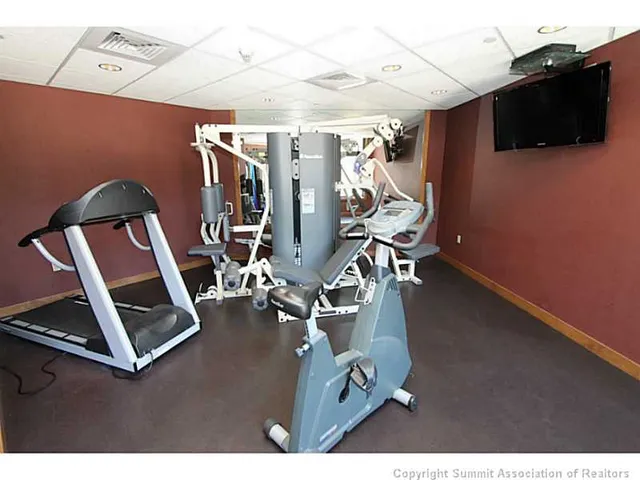 a room with gym equipment and a flat screen tv
