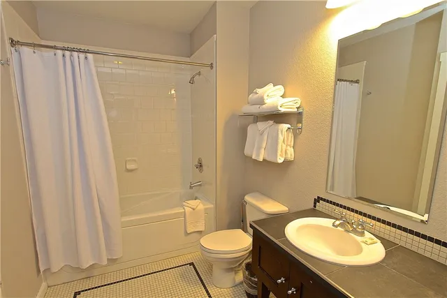 a bathroom with a granite countertop sink toilet and shower