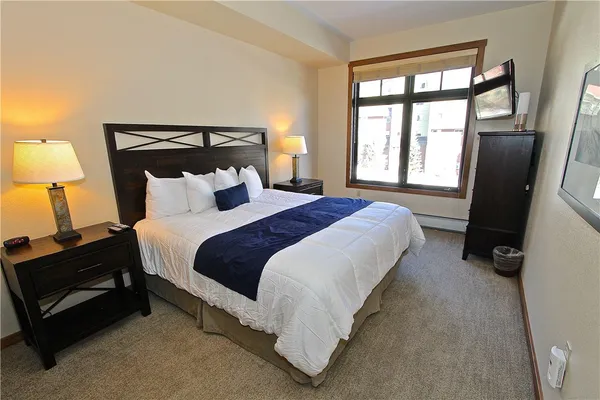 a bedroom with bed and a large window