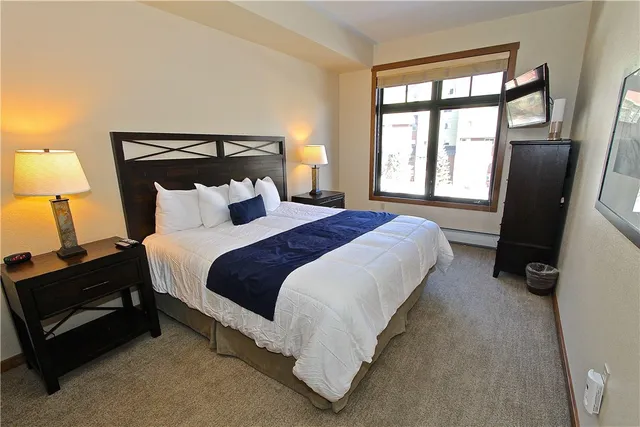 a bedroom with bed and a large window