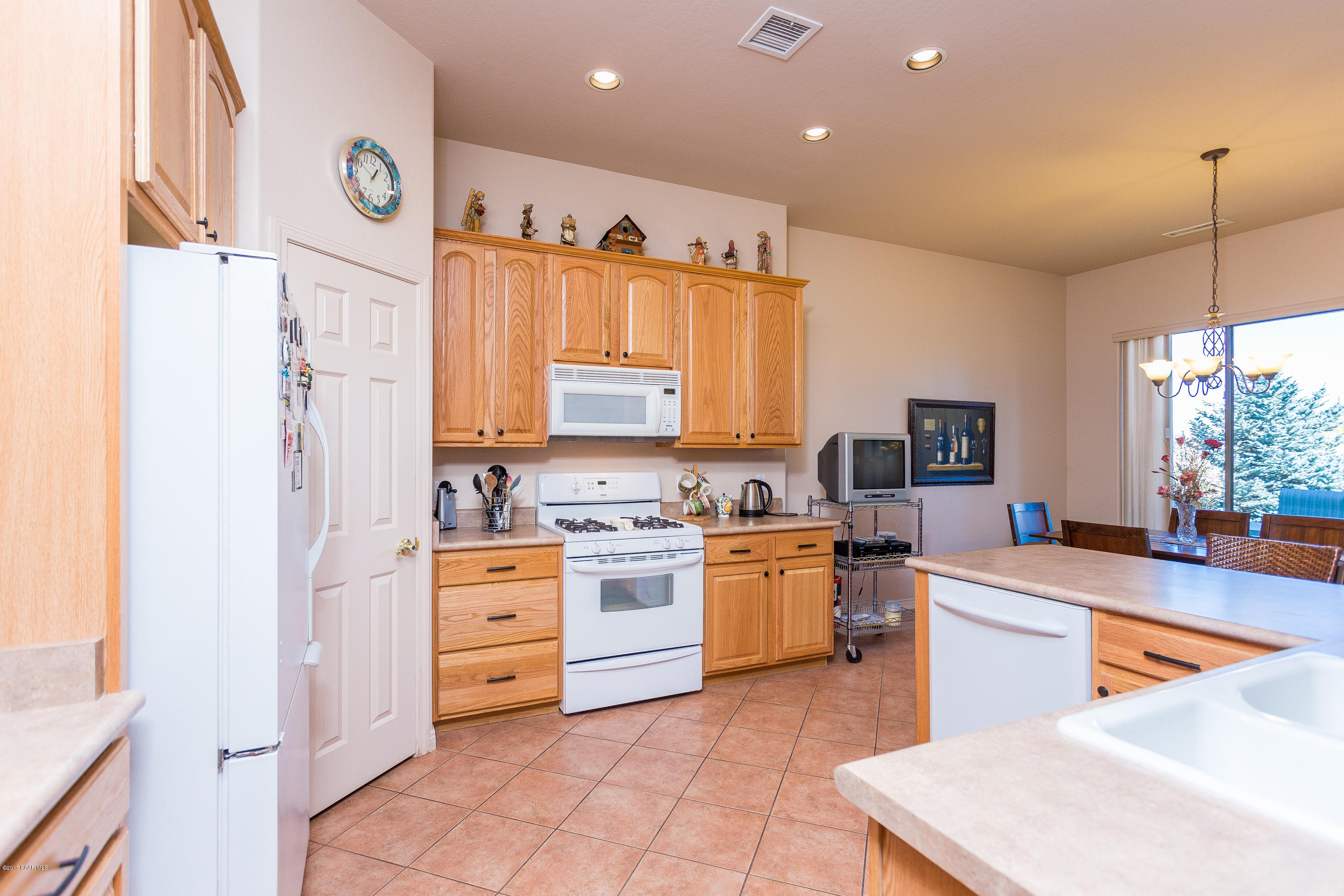 7861 North Rambling Lane Prescott Valley, AZ 86315 - Photo 6 of 15 a large kitchen with stainless steel appliances granite countertop a stove a sink dishwasher and a refrigerator with white cabinets