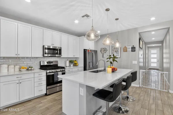 a kitchen with granite countertop a sink a stove top oven a counter space and cabinets