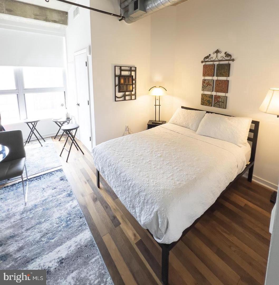 a bedroom with a bed and wooden floor