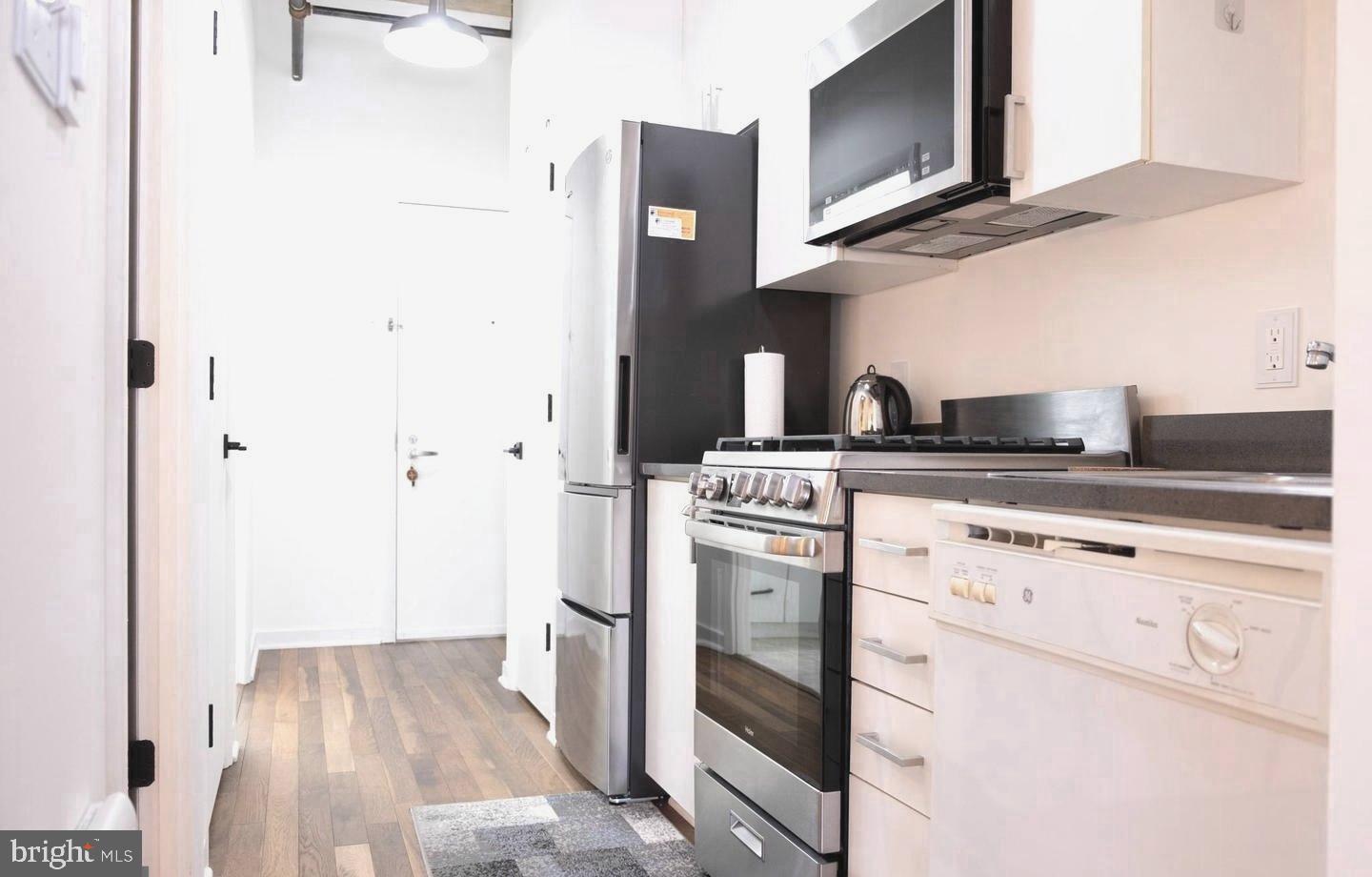 1300 N Street Northwest, Unit 713 Washington, DC 20005 - Photo 11 of 38 a kitchen with stainless steel appliances granite countertop a stove and a microwave