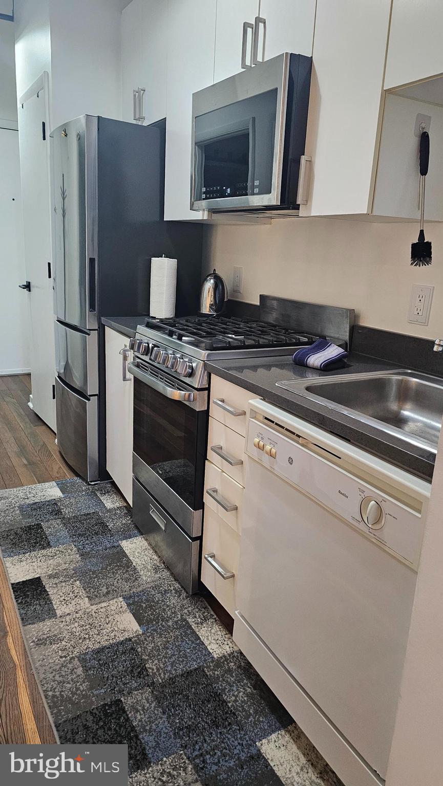1300 N Street Northwest, Unit 713 Washington, DC 20005 - Photo 12 of 33 a kitchen with stainless steel appliances granite countertop a stove a refrigerator and a microwave