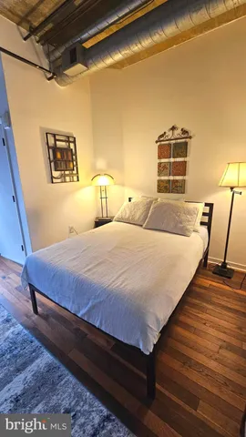 a bedroom with a bed and wooden floor