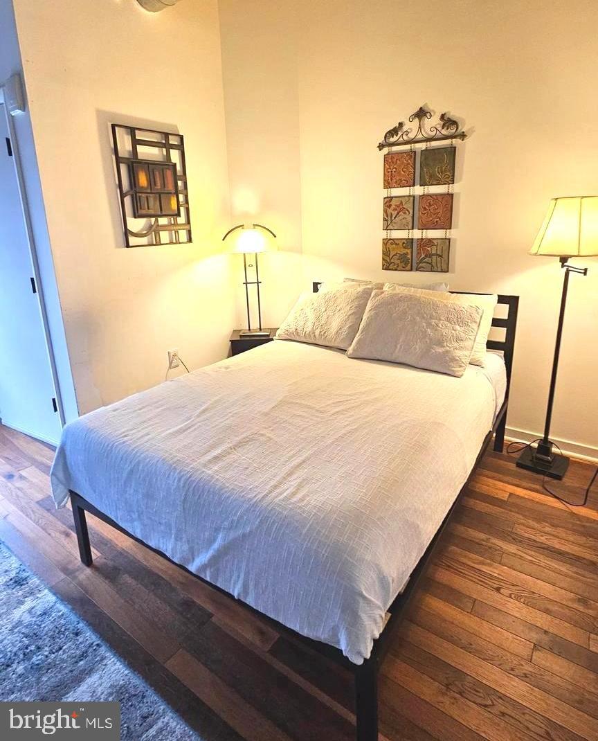 1300 N Street Northwest, Unit 713 Washington, DC 20005 - Photo 18 of 38 a bedroom with a bed and wooden floor