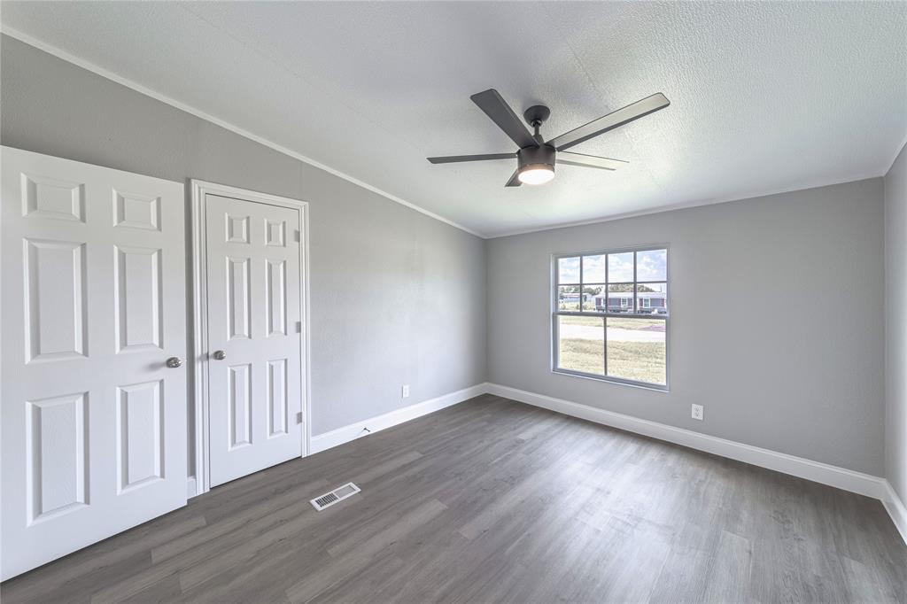 3055 Shanda Court Kaufman, TX 75142 - Photo 8 of 21 Unfurnished bedroom featuring dark wood-style flooring, a closet, a ceiling fan, and crown molding