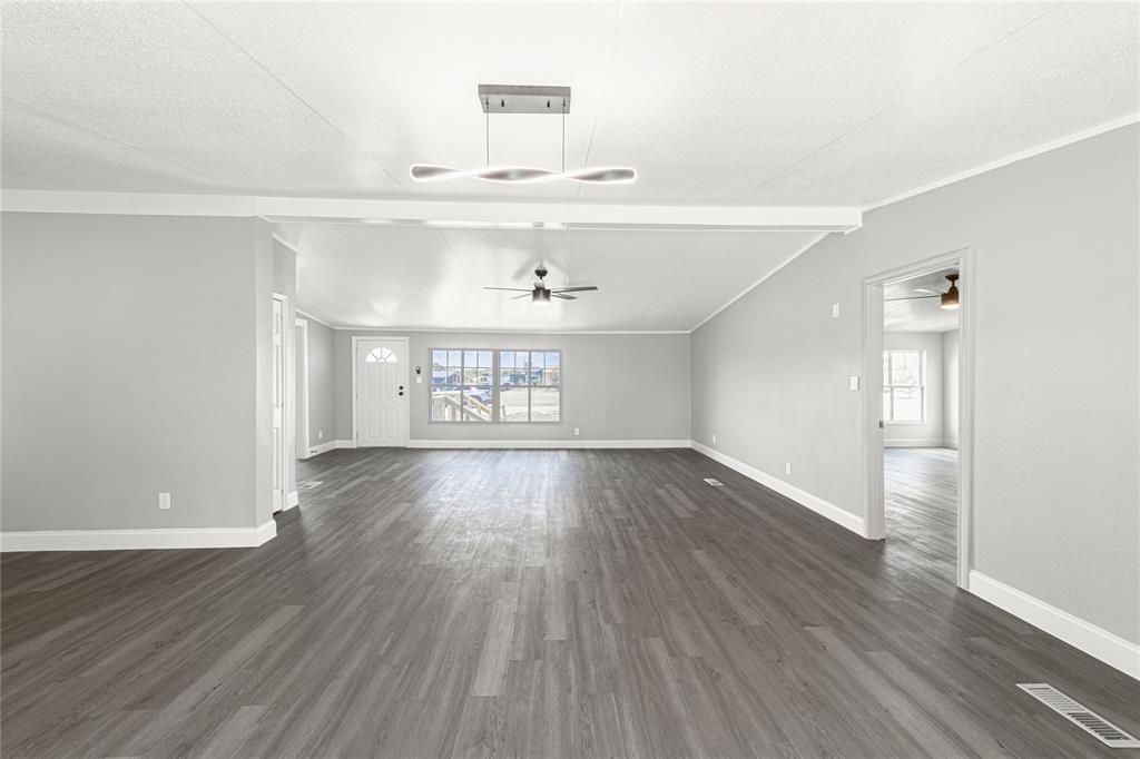 3055 Shanda Court Kaufman, TX 75142 - Photo 10 of 21 Unfurnished living room with dark wood-style flooring, healthy amount of natural light, and ceiling fan