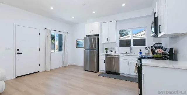 a kitchen with stainless steel appliances granite countertop a refrigerator sink and stove
