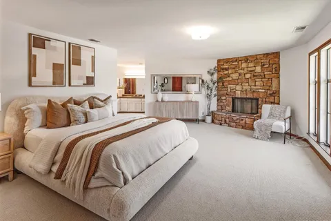 a spacious bedroom with a bed and a large window