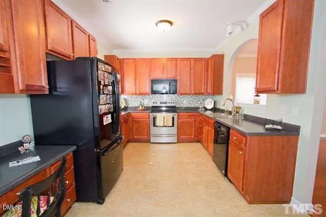 a kitchen with stainless steel appliances granite countertop a stove a sink dishwasher and a refrigerator