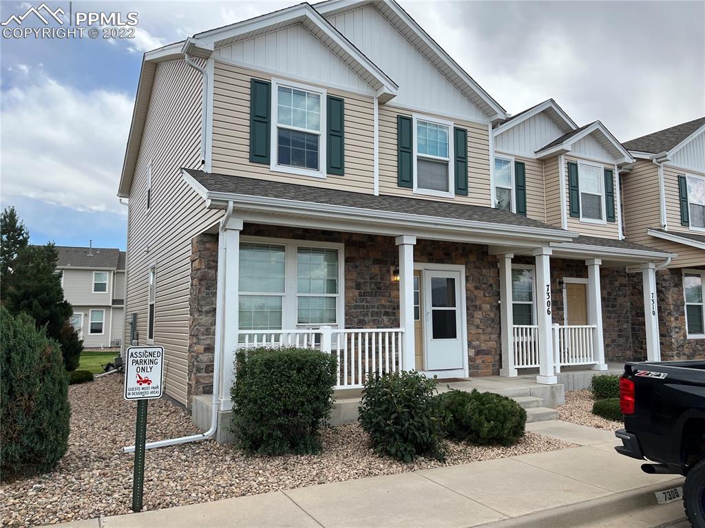 a view of a white house with a potted plant and a large windows
