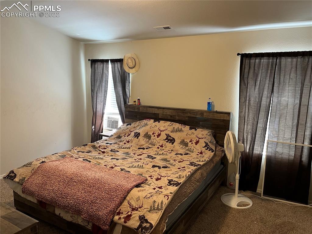 7306 Countryside Grove Fountain, CO 80817 - Photo 8 of 9 a bedroom with a bed and wooden floor