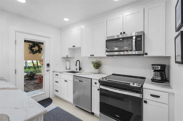 a kitchen with stainless steel appliances granite countertop a stove microwave and cabinets