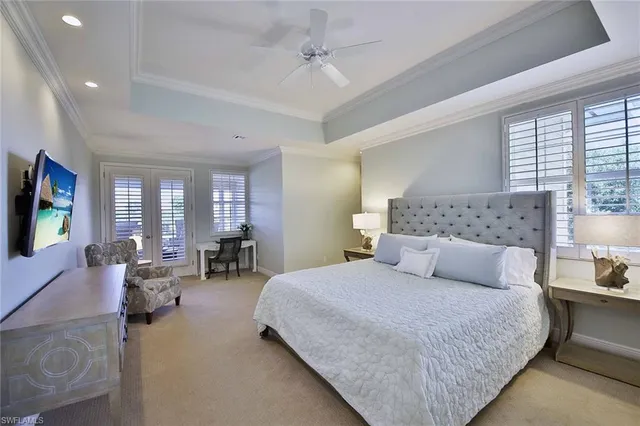 a bedroom with a large bed couch and windows