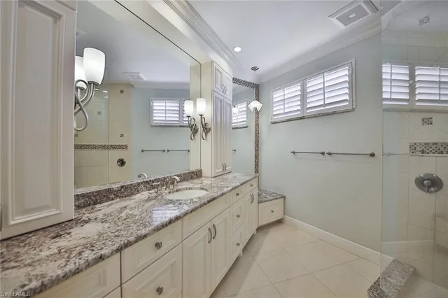 a bathroom with a granite countertop sink a mirror and a shower