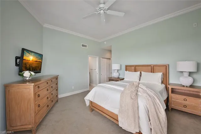 a bedroom with a bed and a flat tv screen on dresser